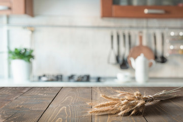 Wooden tabletop with wheat on blur kitchen room background for montage product.