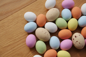 Multicolored chocolate Easter eggs on wooden table. Easter background
