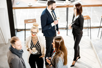 Business people having a conversation during the coffee break standing in the cafe