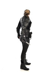 full length portrait of female  soldier wearing black  tactical armour, holding a remote knife, isolated on white studio background.