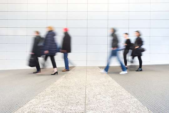 blurred commuters at a modern corridor