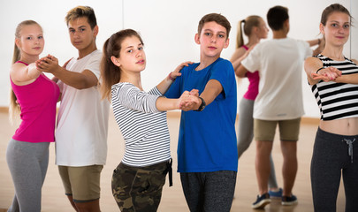 Teen boys and girls having dancing class