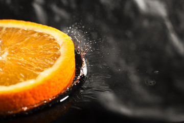 Fototapeta na wymiar an orange ring with splashes of water, a fruit with splashes