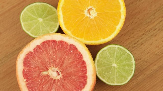 Grapefruit, orange and lime in a section on on a wooden board 