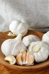 Garlic close up on wooden plate on rustic background, shallow depth of field, selective focus, macro