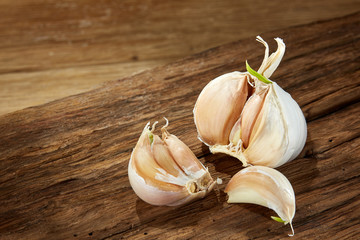 Garlic close up on wooden plate on rustic background, shallow depth of field, selective focus, macro
