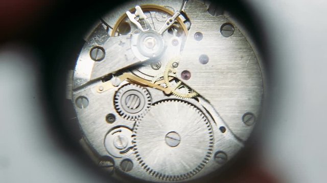 Clockwork mechanism under watchmaker magnifying glass