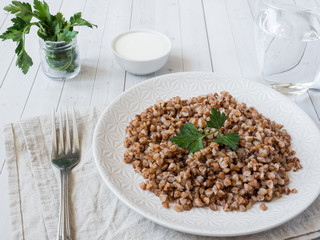 Buckwheat porridge with parsley leaves in a plate, healthy food