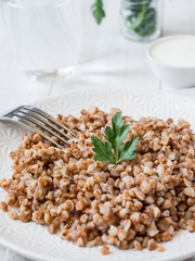Buckwheat porridge with parsley leaves in a plate, healthy food