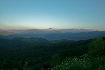 he mountain is covered with forest, in the evening.