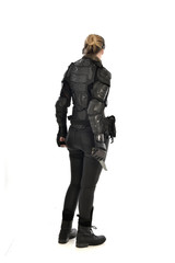 full length portrait of female  soldier wearing black  tactical armour, holding a remote knife, isolated on white studio background.