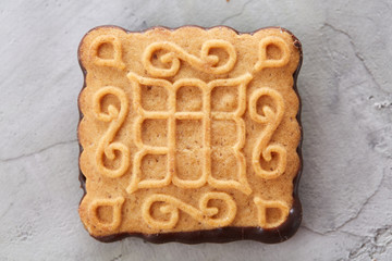 Square biscuits arranged in pattern on light textured background, close-up, shallow depth of field, selective focus.