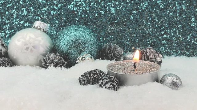 Small silver christmas candle with glitter,snow and baubles in blue and silver
