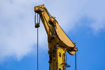 Detail view from a yellow crane in front of blue sky