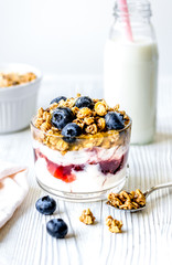 Homemade fitness granola with yoghurt and berries on white kitch