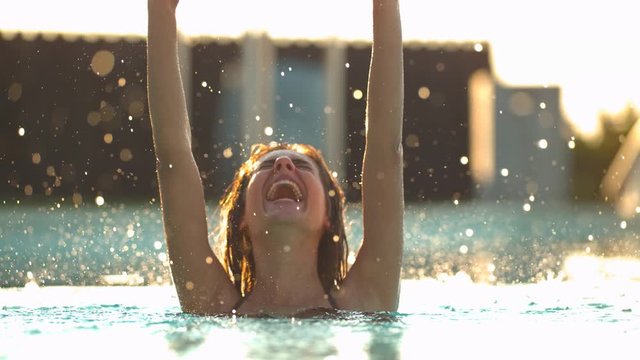 Young woman having fun in a water pool