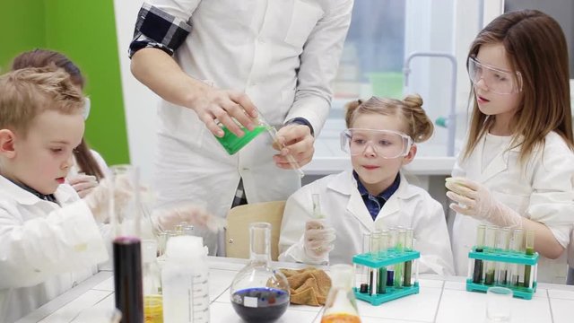 Children do an experiment in a chemistry lesson. modern education