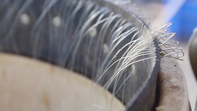 Fisherman prepares hooks in basket for longline fishing. Extreme close up.