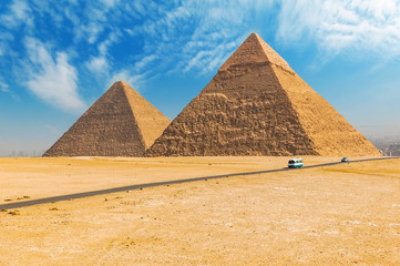 Fototapeta na wymiar The Egyptian pyramids of Giza on the background of Cairo. Miracle of light. Architectural monument. The tombs of the pharaohs. Vacation holidays background wallpaper