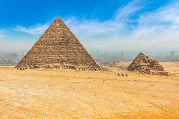 The Egyptian pyramids of Giza on the background of Cairo. Miracle of light. Architectural monument. The tombs of the pharaohs. Vacation holidays background wallpaper © Anton Belo