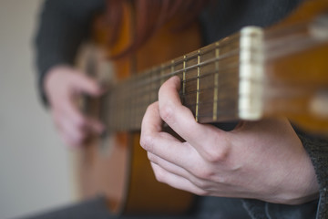 Woman hands playing acoustic guitar. Selective focus