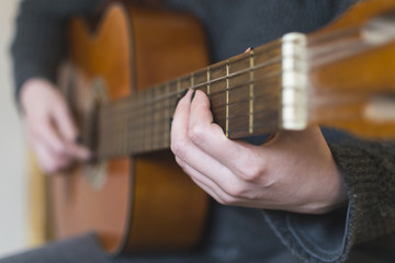 Fototapeta premium Woman hands playing acoustic guitar. Selective focus