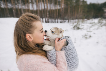 beautiful young woman holding husky puppy in winter park © LIGHTFIELD STUDIOS