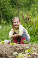 Little girl having fun in the garden, planting, gardening, helping her mother. Happy, natural childhood concept. 