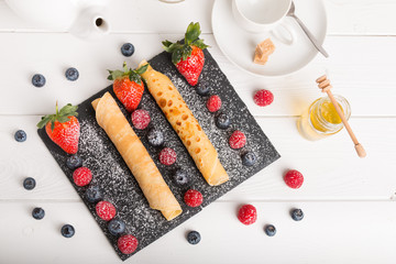 rolled pancakes with fresh fruit and coffee