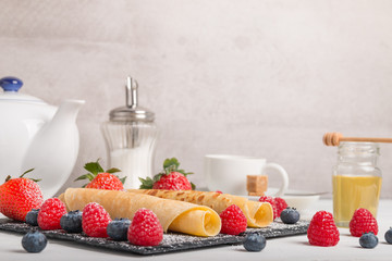rolled pancakes with fresh fruit and coffee