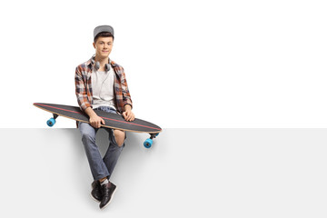 Teenage skater with a longboard sitting on a panel © Ljupco Smokovski