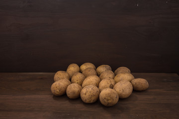 Fototapeta na wymiar rohe ungeschälte Kartoffeln im Keller Holz Antik Look 