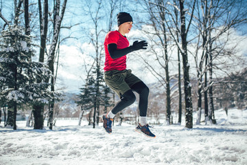 Fototapeta na wymiar Young man running at winter in park