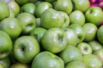 New green apples for sale at city market.
