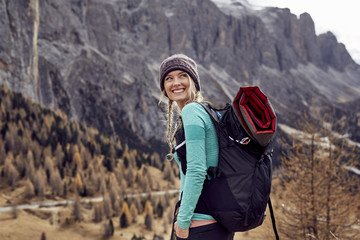 Portrait of smiling young woman hiking in mountains