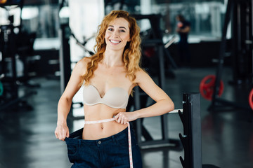 Fototapeta premium Woman with red hair shows her weight loss.