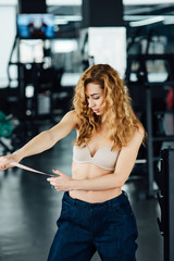 Woman with red hair shows her weight loss.