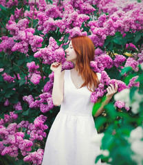 girl standing near lilac bushes in the park