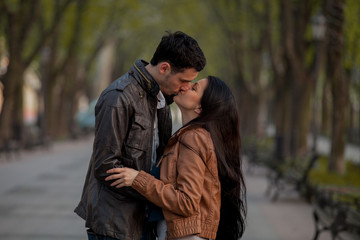 Young couple kissing on the street in springtime