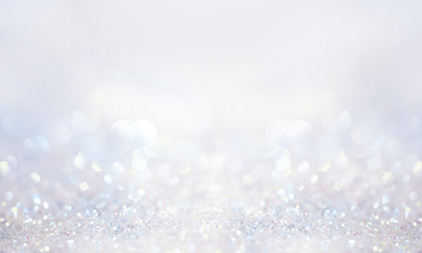 Glitter background in pastel delicate silver and white tones de-focused.