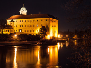 Fototapeta na wymiar Illuminated Podebrady Castle at Labe River by night, Czech Republic.