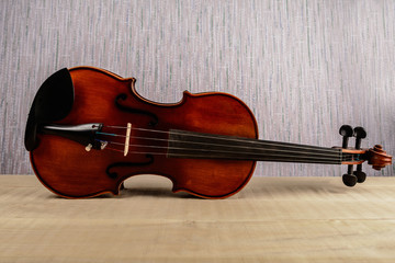 Fototapeta na wymiar The violin lies horizontally on a wooden table
