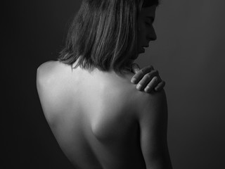 Feminine young man. Back view. Portrait on a black background. Black and White