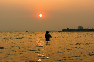 fisherman with his net and  in the sea in beautiful sunset
