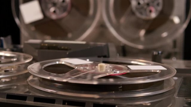 Two Reel to Reel tape recorders playing music together with four tapes