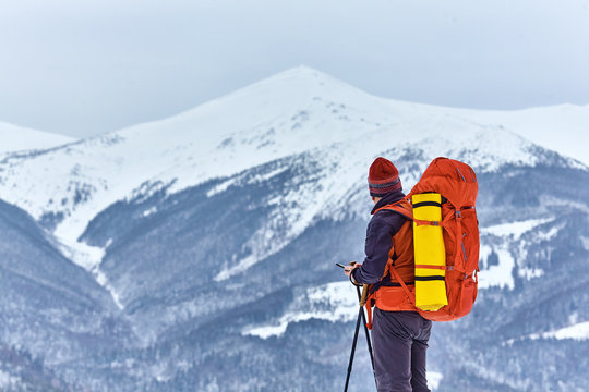 Man hiking at sunset mountains with heavy backpack.