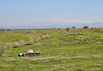 Blasted tank in the Golan Heights against the backdrop of Mount Hermon