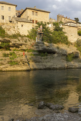 People diving into Neretva river in Mostar at sunset time