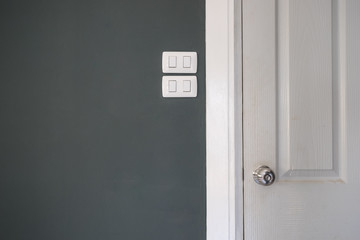 white smoke door and lighting switch in dark gray room