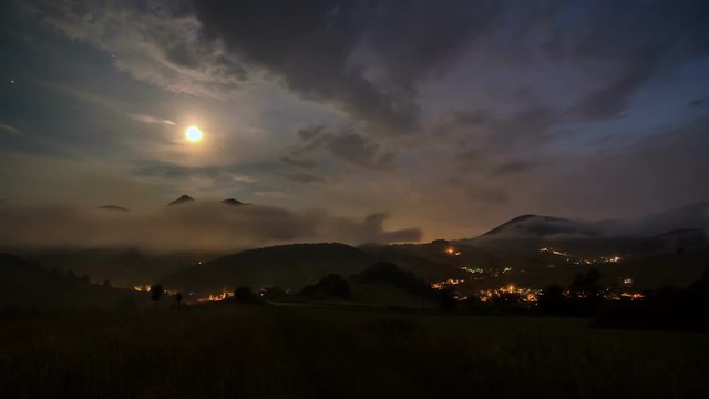 Moonlight night with fast moving clouds over rural country Time lapse